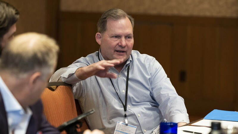 A CEO Exchange leader gesturing during a roundtable discussion