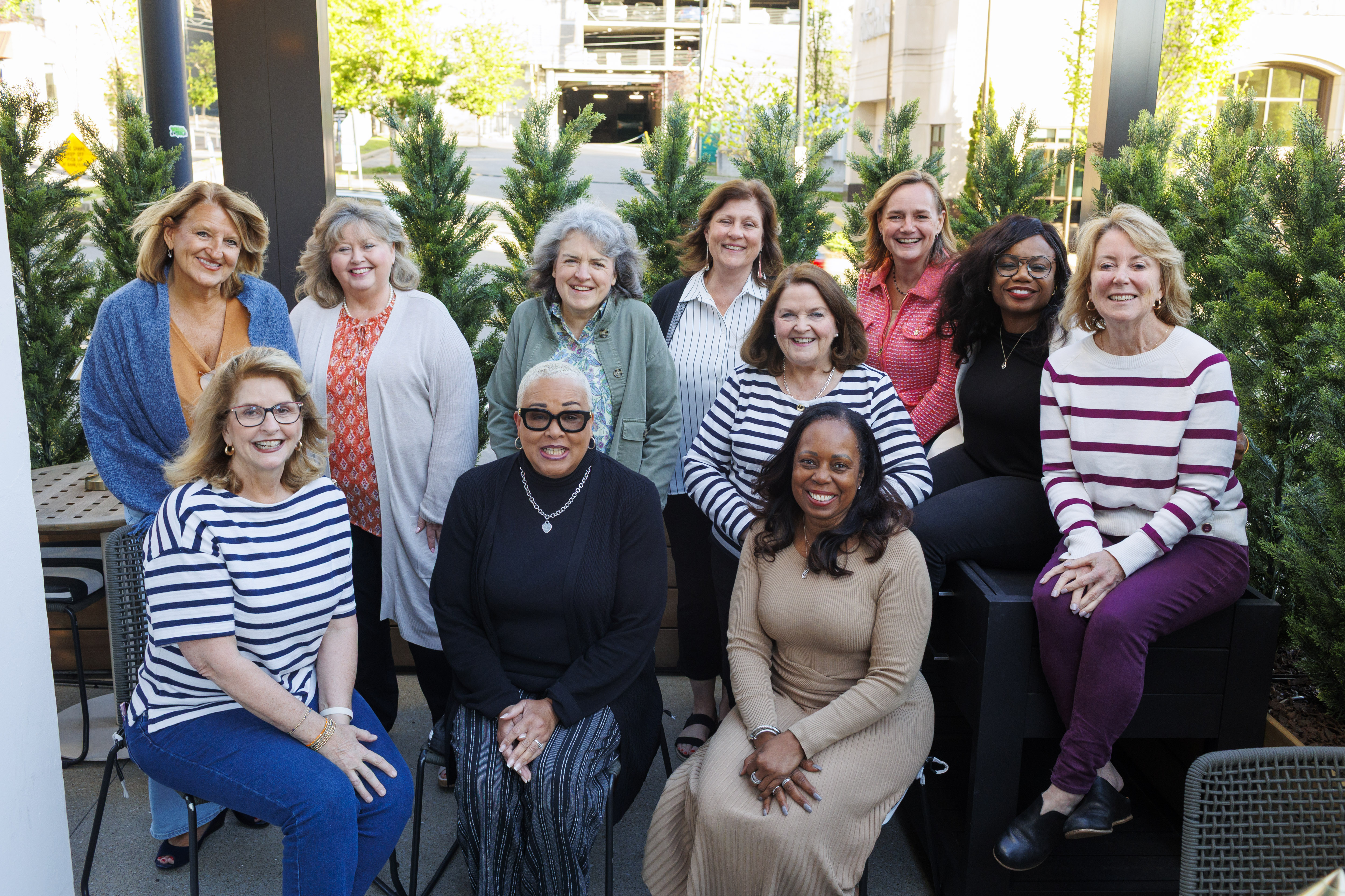 A group of HealthLeaders Exchange women leaders smiling together on an outdoor patio