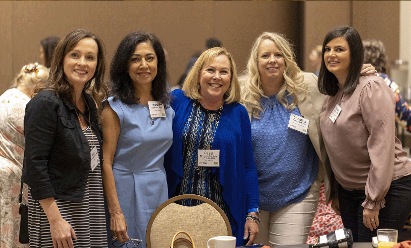 Five HealthLeaders Exchange members smiling together at a conference reception